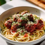 Homemade classic Italian meatballs in marinara sauce served with spaghetti.
