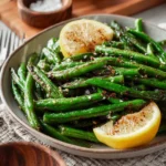Plate of grilled green beans garnished with herbs and spices