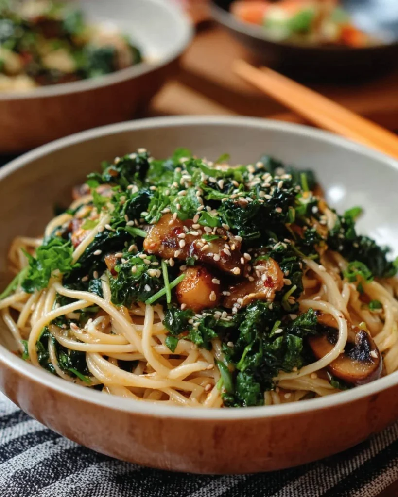 Kale and mushroom soba noodle stir fry served in a bowl with chopsticks
