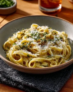 Delicious creamy garlic pasta garnished with herbs in a bowl