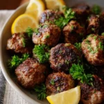 Delicious Greek meatball dish (Keftedes) served with herbs and sauce.