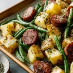 Sheet pan sausage with roasted potatoes and green beans on a baking tray