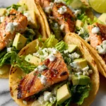 Baked salmon tacos served with fresh toppings in a colorful presentation.