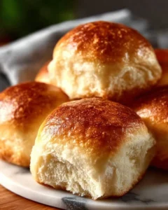 Freshly baked easy homemade dinner rolls on a wooden table