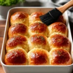 Freshly baked homemade dinner rolls on a wooden table