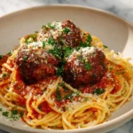 Plate of delicious spaghetti and meatballs with marinara sauce and parmesan cheese.