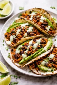 Black bean quinoa tacos served with cilantro lime cashew crema on a plate