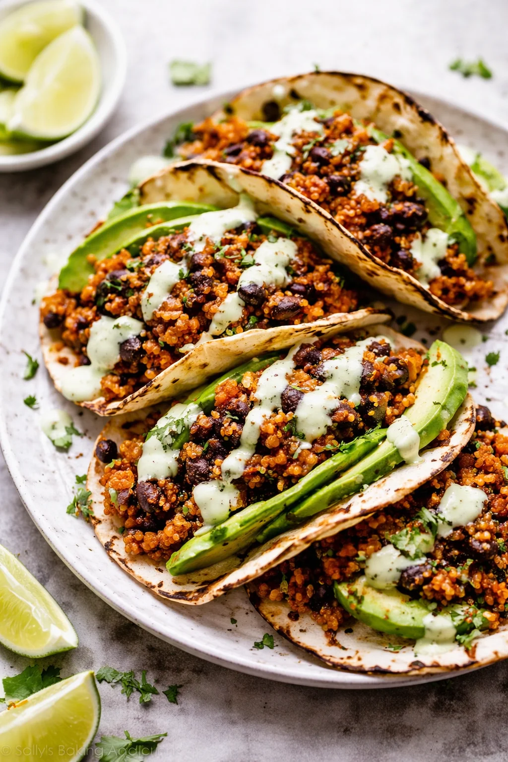 Black bean quinoa tacos served with cilantro lime cashew crema on a plate