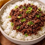 Quick ground beef rice bowl topped with fresh vegetables and herbs