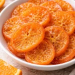 Homemade candied orange slices on a wooden surface