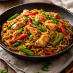 Plate of Chicken Lo Mein with vegetables and chicken stir-fried in sauce.