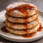 Delicious churro pancakes topped with cinnamon sugar and chocolate sauce.