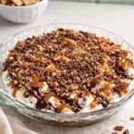 Turtle cheesecake dip served in a bowl with chocolate and caramel toppings.