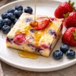 Delicious baked yogurt dessert served in a bowl with fresh fruits and mint.
