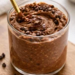 Delicious bowl of brownie batter overnight oats topped with chocolate and nuts