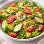 Classic house salad with fresh greens, tomatoes, cucumbers, and dressing.