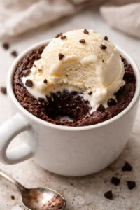 Easy eggless mug brownie in a microwavable mug, topped with chocolate chips.