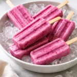 Greek yogurt popsicles with berries in a vibrant summer setting.