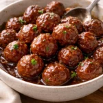 Delicious meatballs in grape jelly and chili sauce served on a platter.