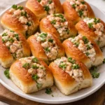 Mini shrimp rolls served on a plate with fresh herbs and dipping sauce