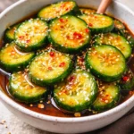Bowl of Asian cucumber salad with colorful vegetables and dressing