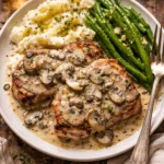 Creamy mushroom pork chops served on a plate with garnish