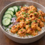 Plate of crispy chicken with spicy creamy sauce served on jasmine rice