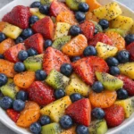 Colorful fresh fruit salad with honey lime poppy seed dressing