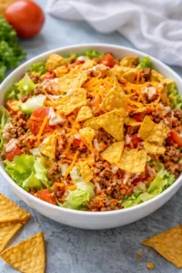 A colorful bowl of Simple Doritos Taco Salad with crunchy toppings and fresh ingredients.