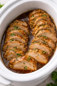 Succulent slow cooker pork tenderloin served with vegetables.