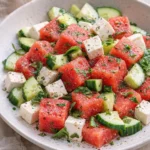 Refreshing watermelon salad with cucumber and feta cheese on a plate.