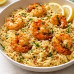 Plate of vibrant shrimp orzo topped with lemon garlic sauce