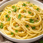 Lemon pasta with butter garlic sauce in a bowl garnished with herbs